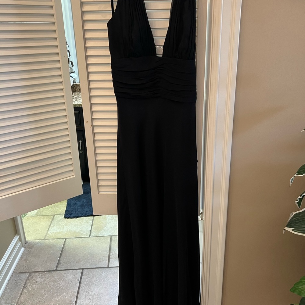 Long black evening dress with a silver clip holding the front bodice.